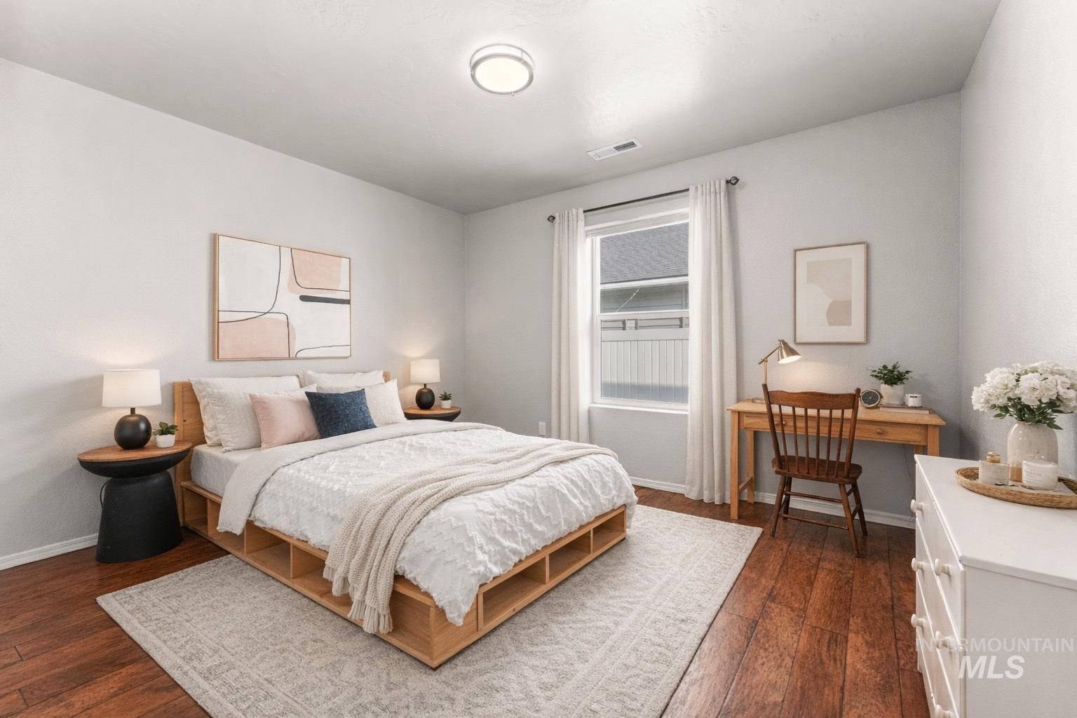 Bedroom with dark wood-type flooring and baseboards