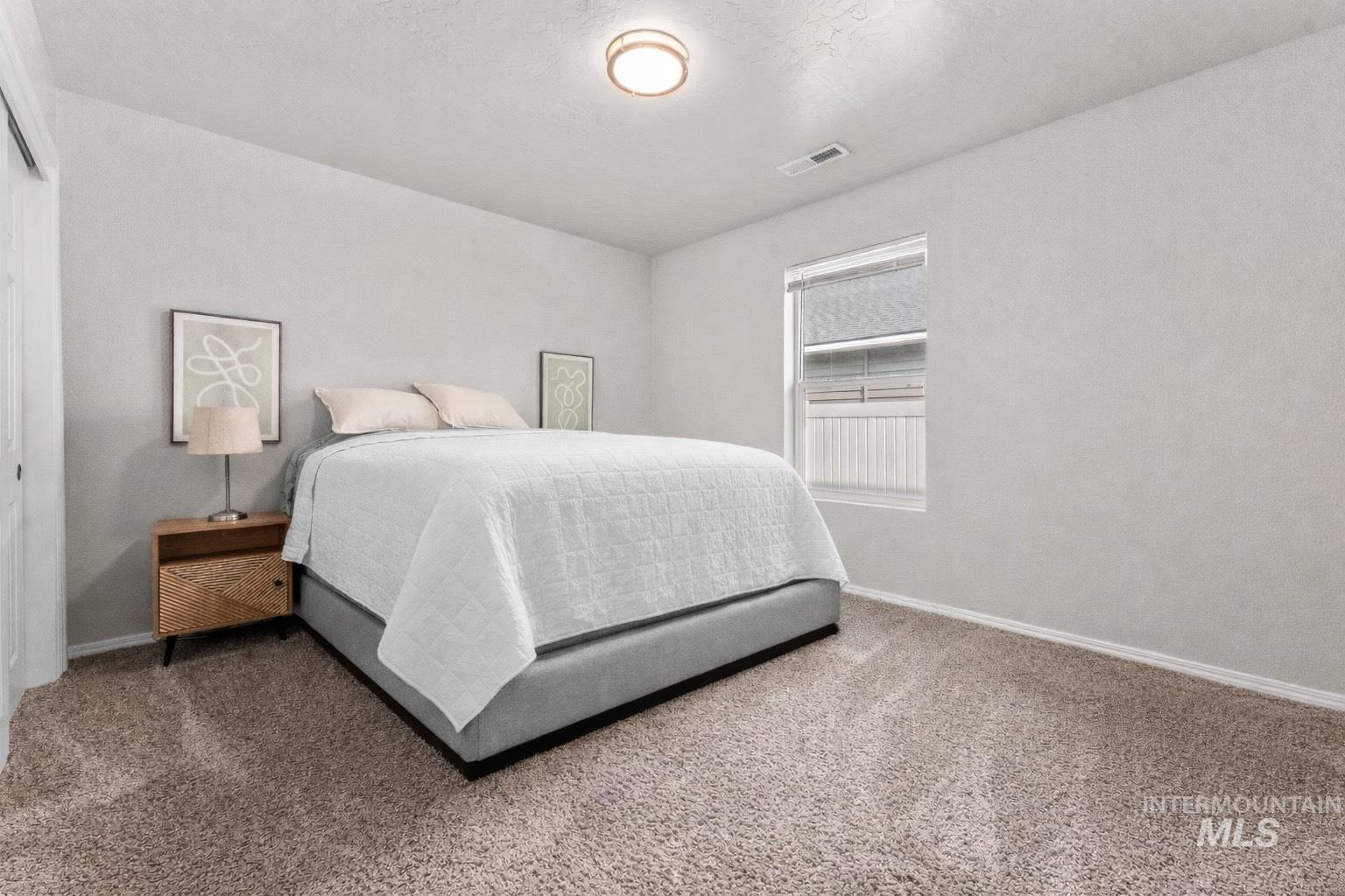 Carpeted bedroom with baseboards and a textured ceiling