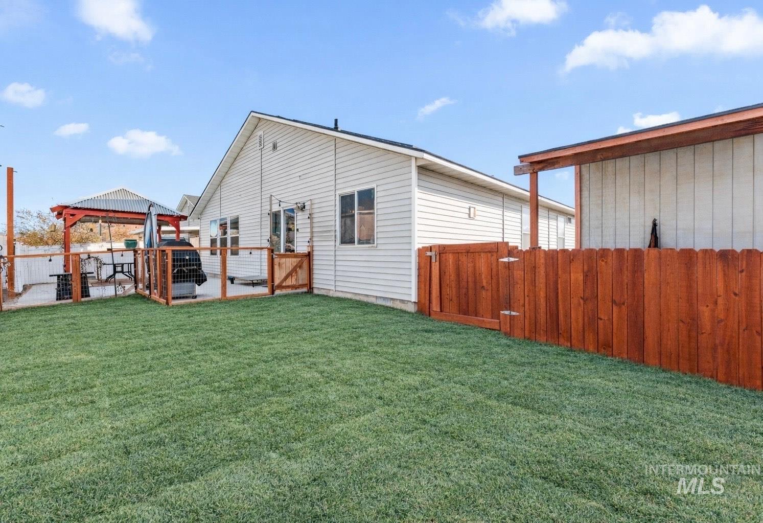 View of yard with a gazebo, a gate, and a patio