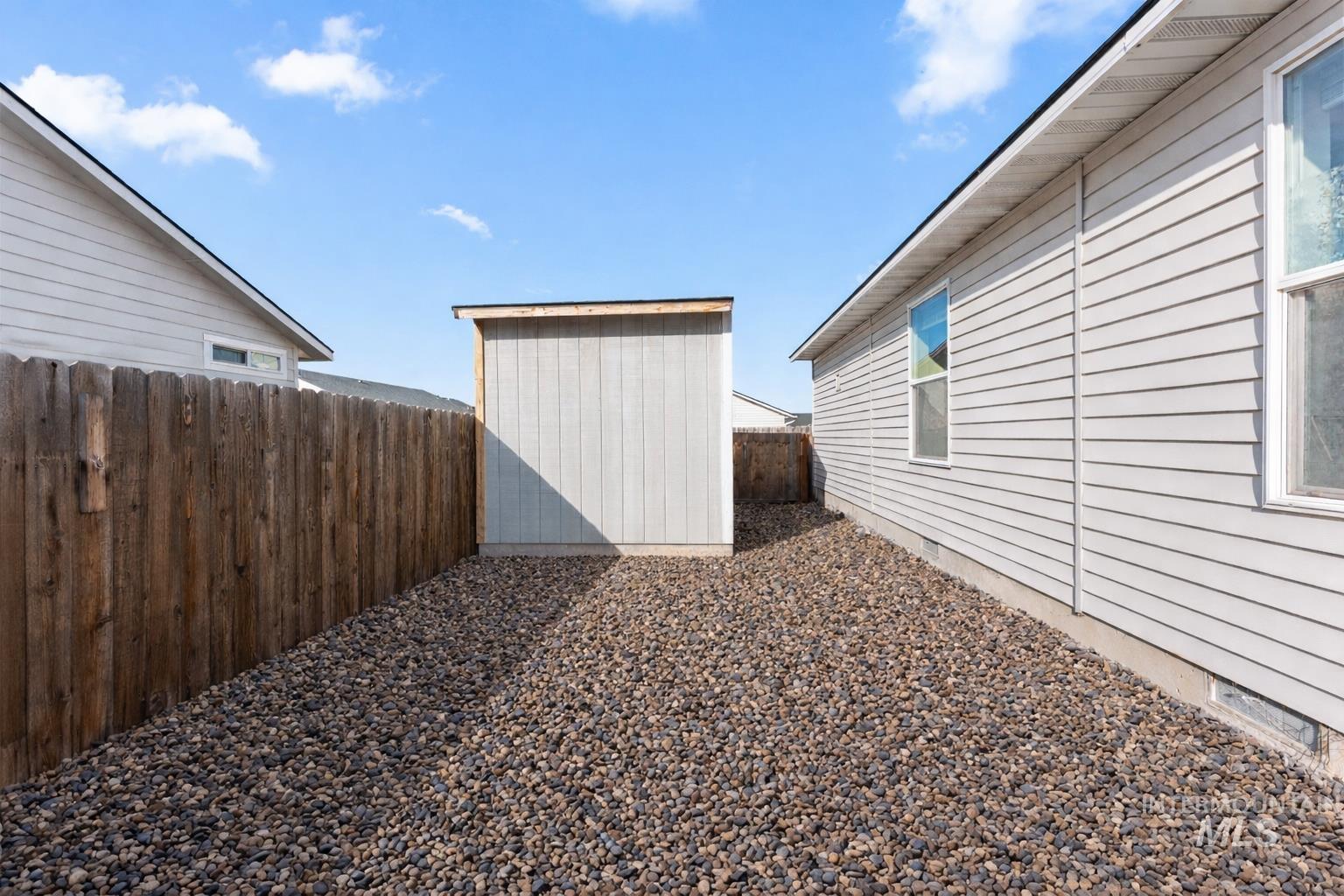 Fenced backyard with a storage unit