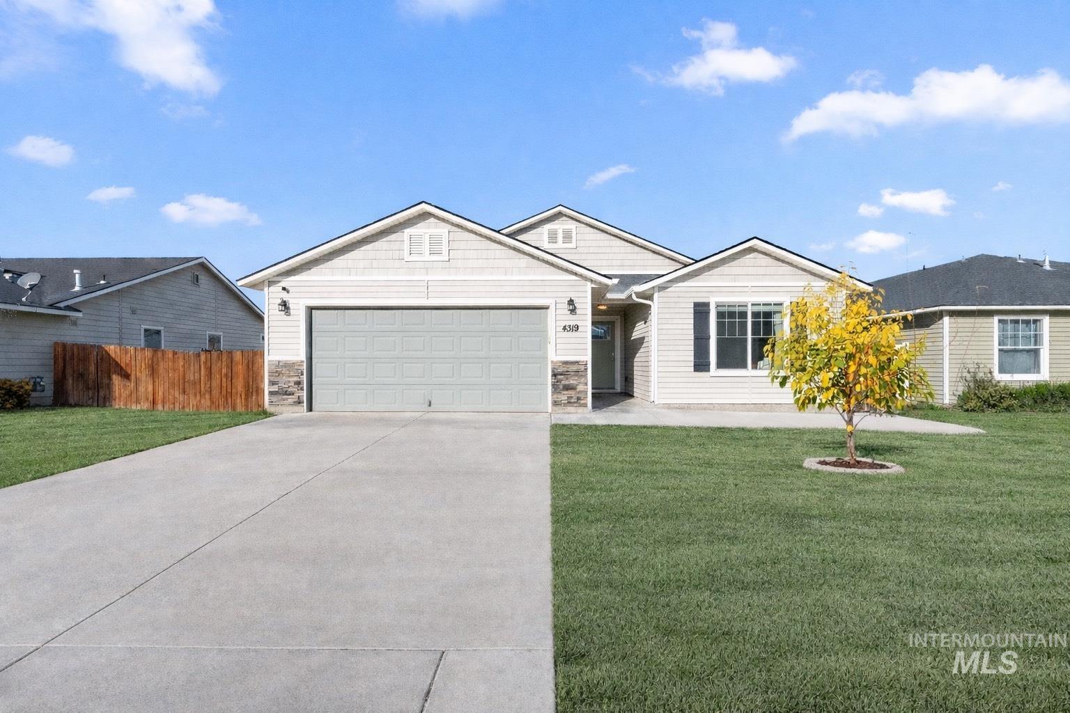 View of front of house with concrete driveway, stone siding, and a garage