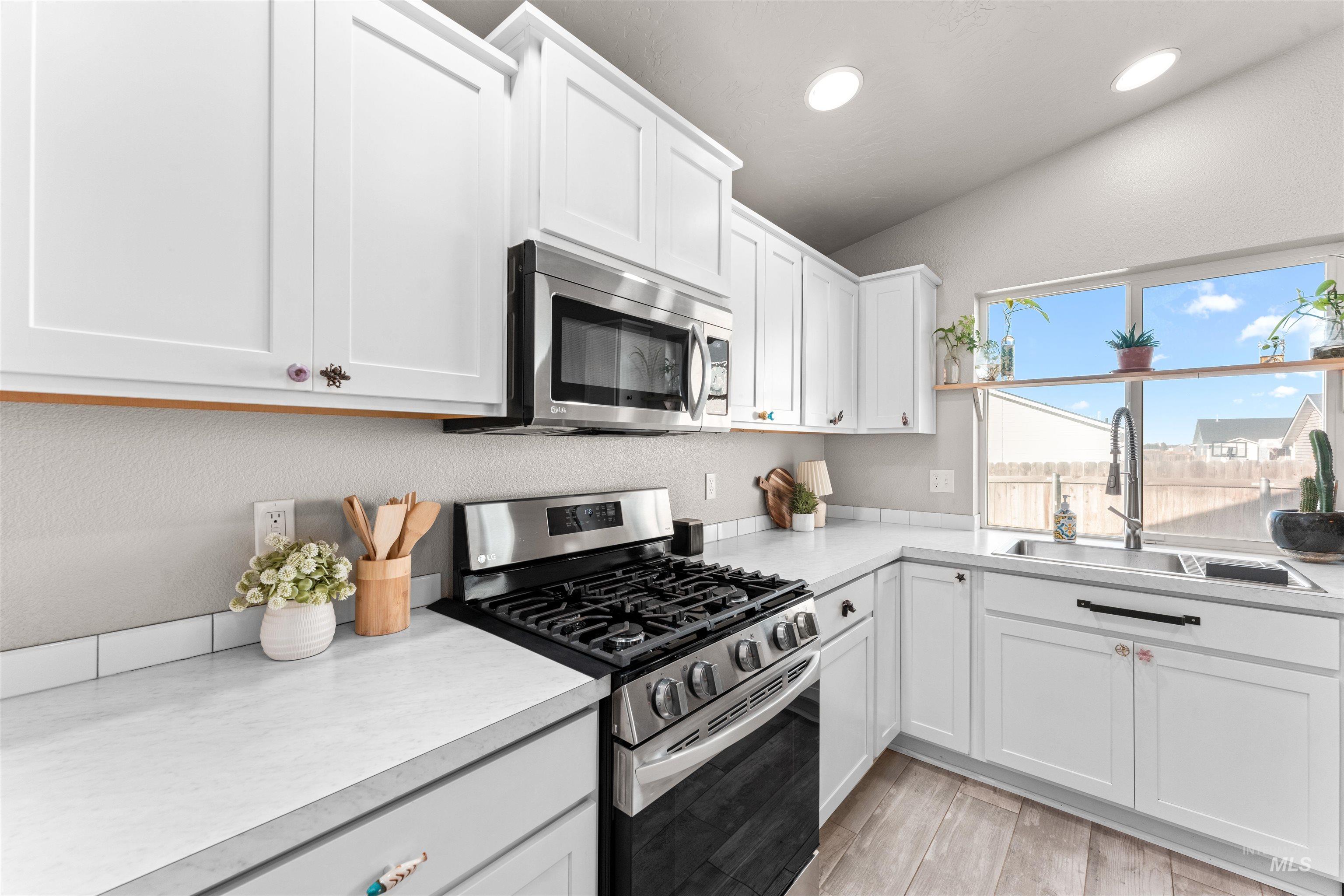 Kitchen featuring appliances with stainless steel finishes, white cabinets, light countertops, and recessed lighting