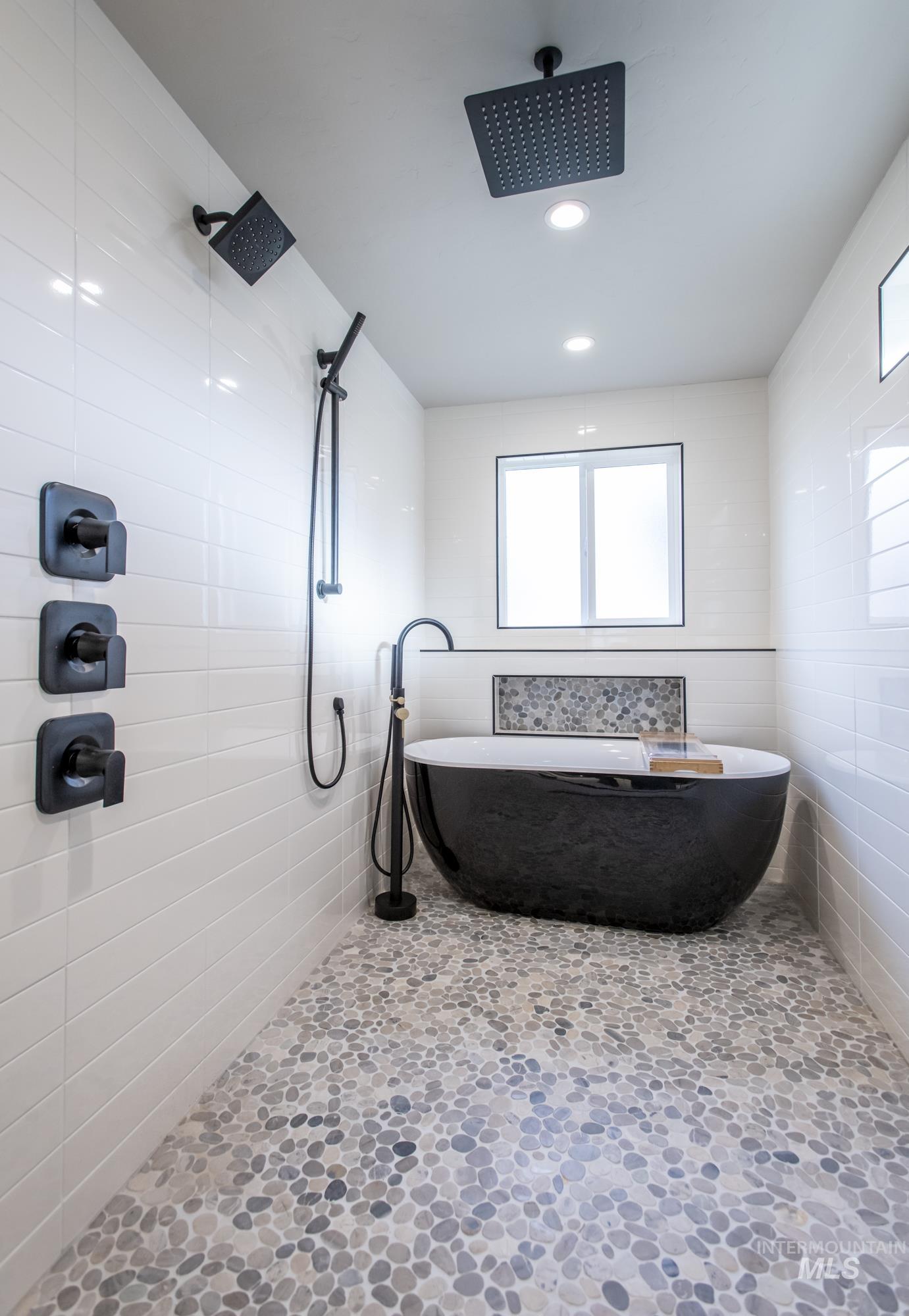 Primary Bathroom wet-room featuring multiple shower heads, rain shower, a freestanding bath, recessed lighting, and tile walls.