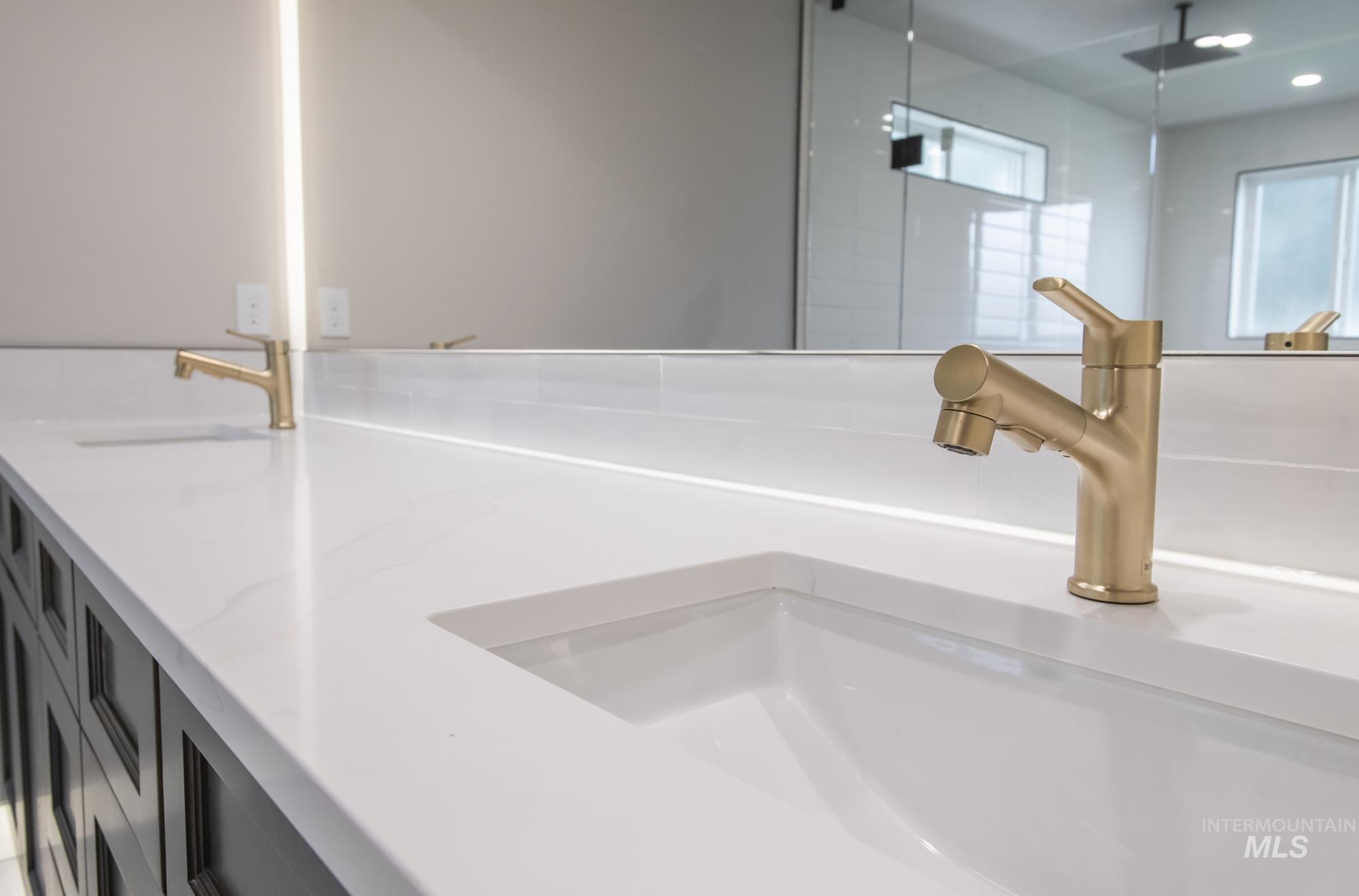 Primary Bathroom view of wet-room reflected in the massive backlit mirror and vanity with kickboard lighting.