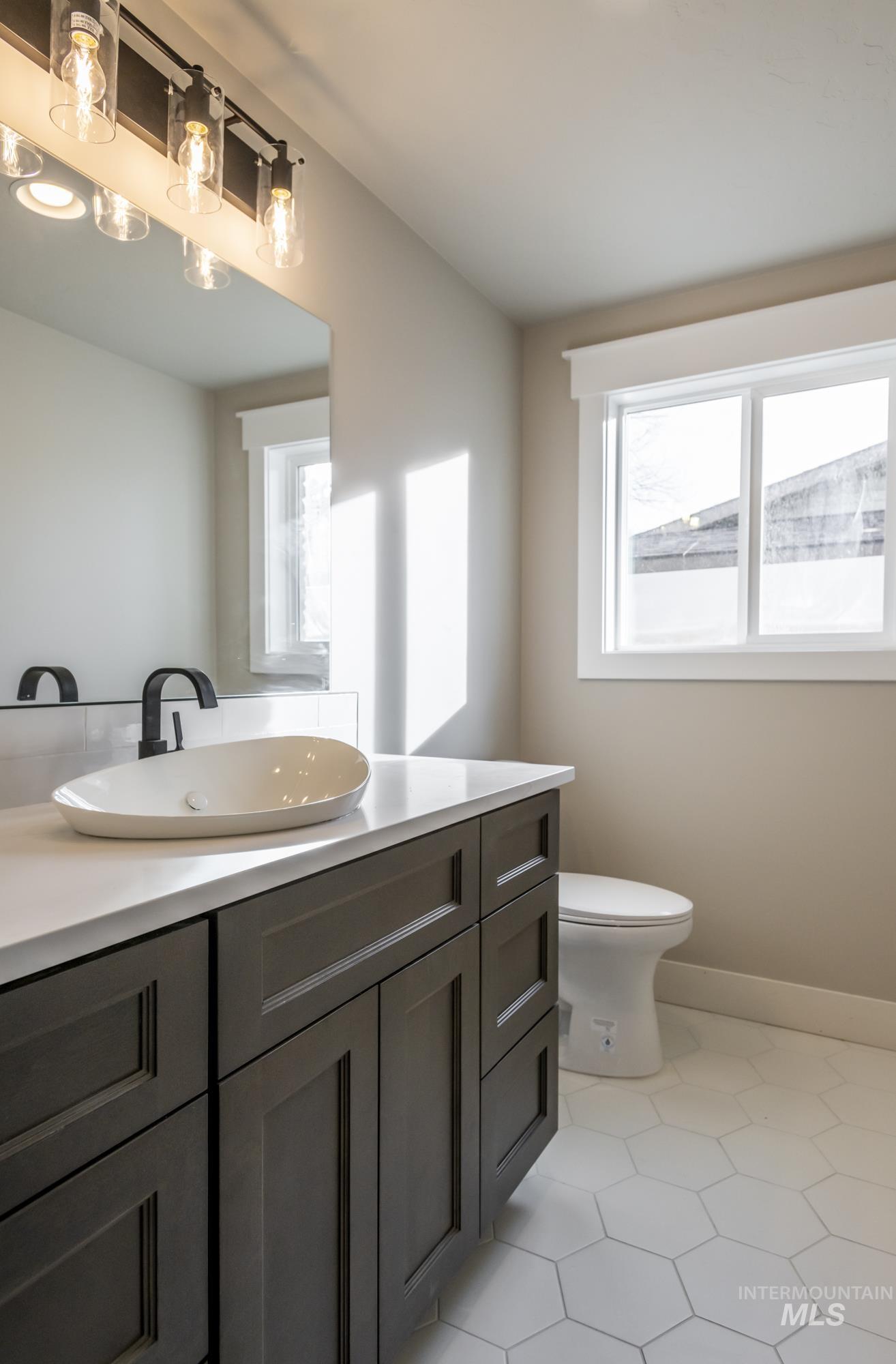 Half bath featuring light tile patterned floors and vanity