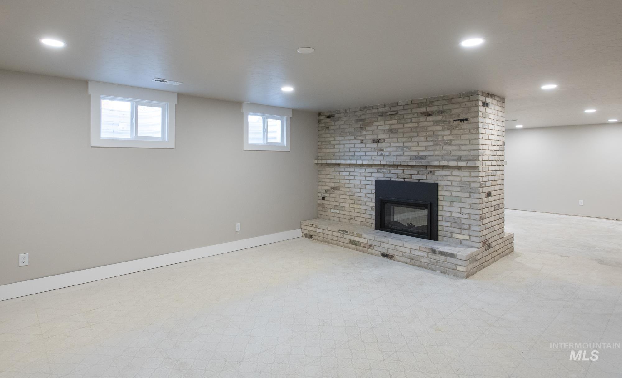 Huge room featuring a double sided fireplace, light flooring, and recessed lighting