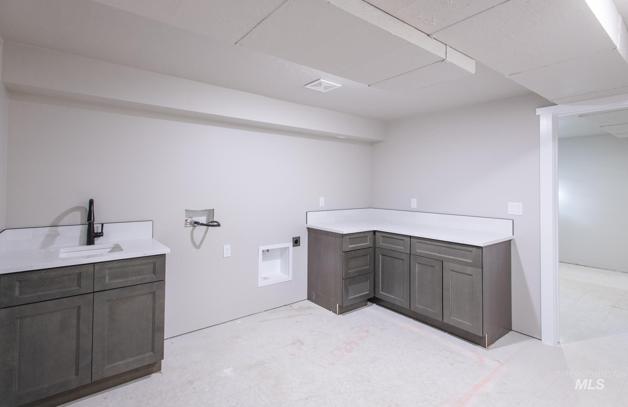 1 of 2 Laundry areas. Laundry room featuring cabinet space, quartz countertops, and lots of space.