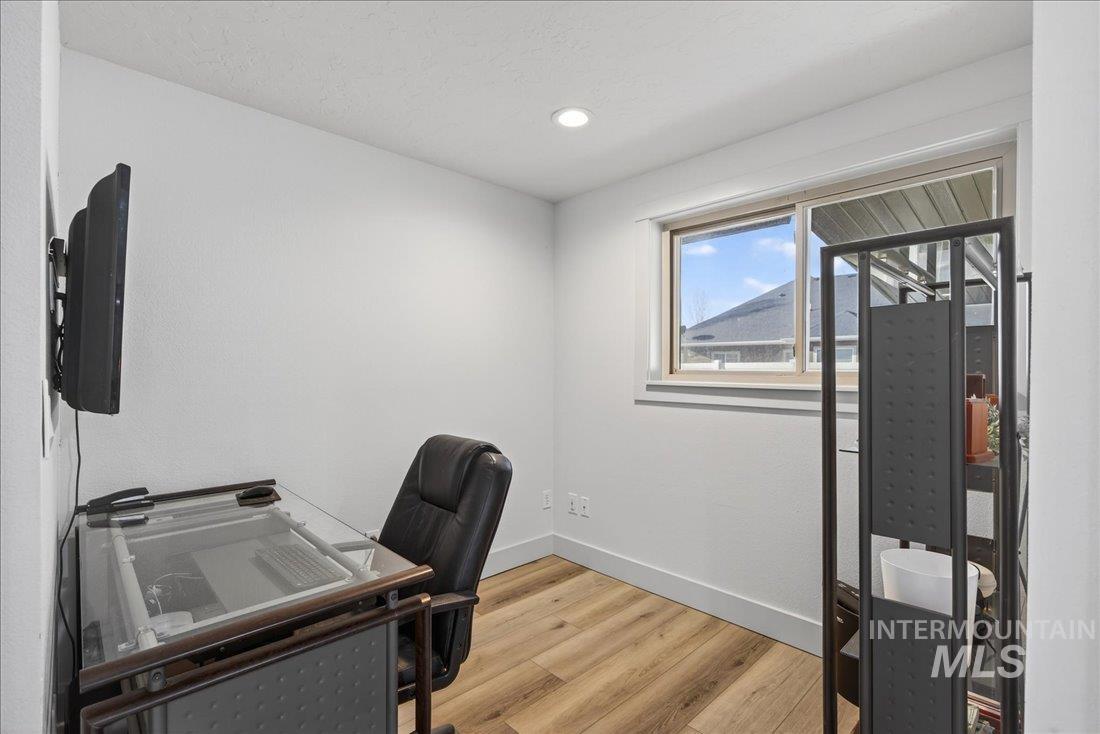Office area featuring light wood-style floors and recessed lighting