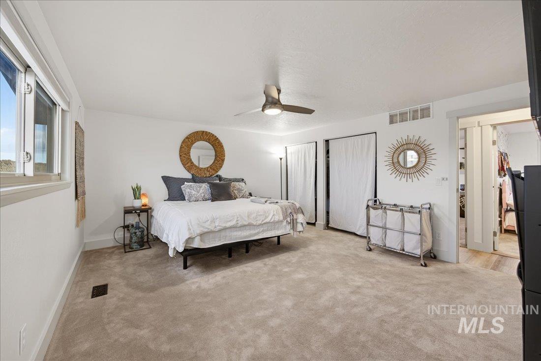 Bedroom featuring multiple closets, carpet floors, and a ceiling fan
