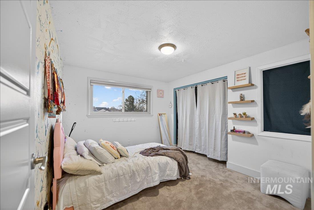 Bedroom with carpet and a textured ceiling