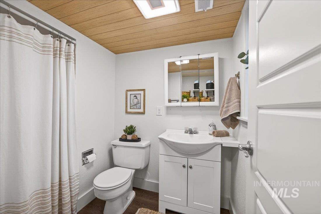 Bathroom featuring wood ceiling, vanity, a shower with curtain, and dark wood-type flooring