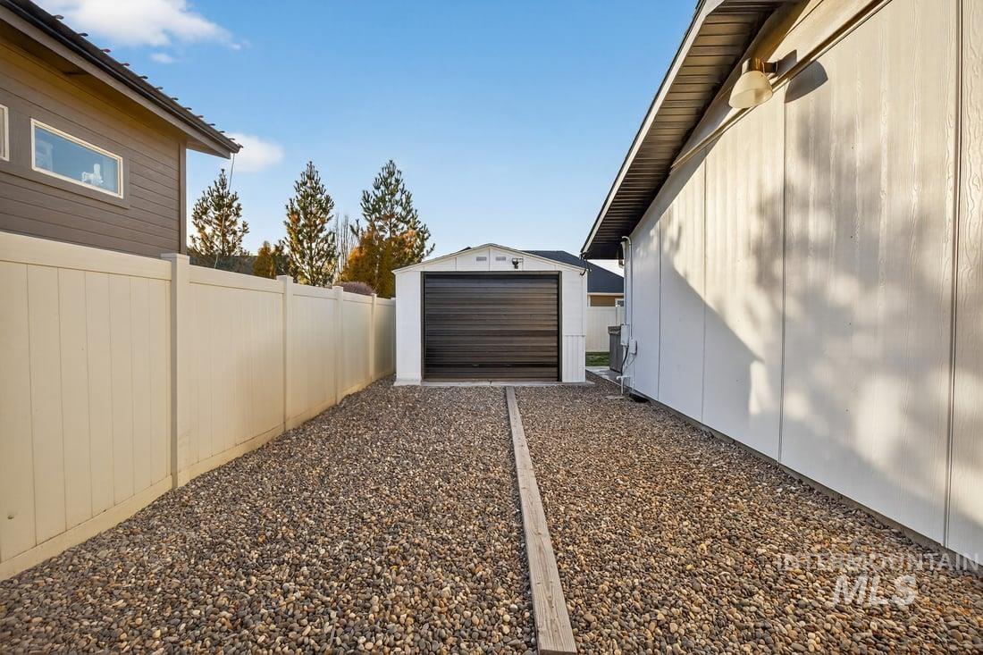 View of side of property with an outbuilding and a detached garage