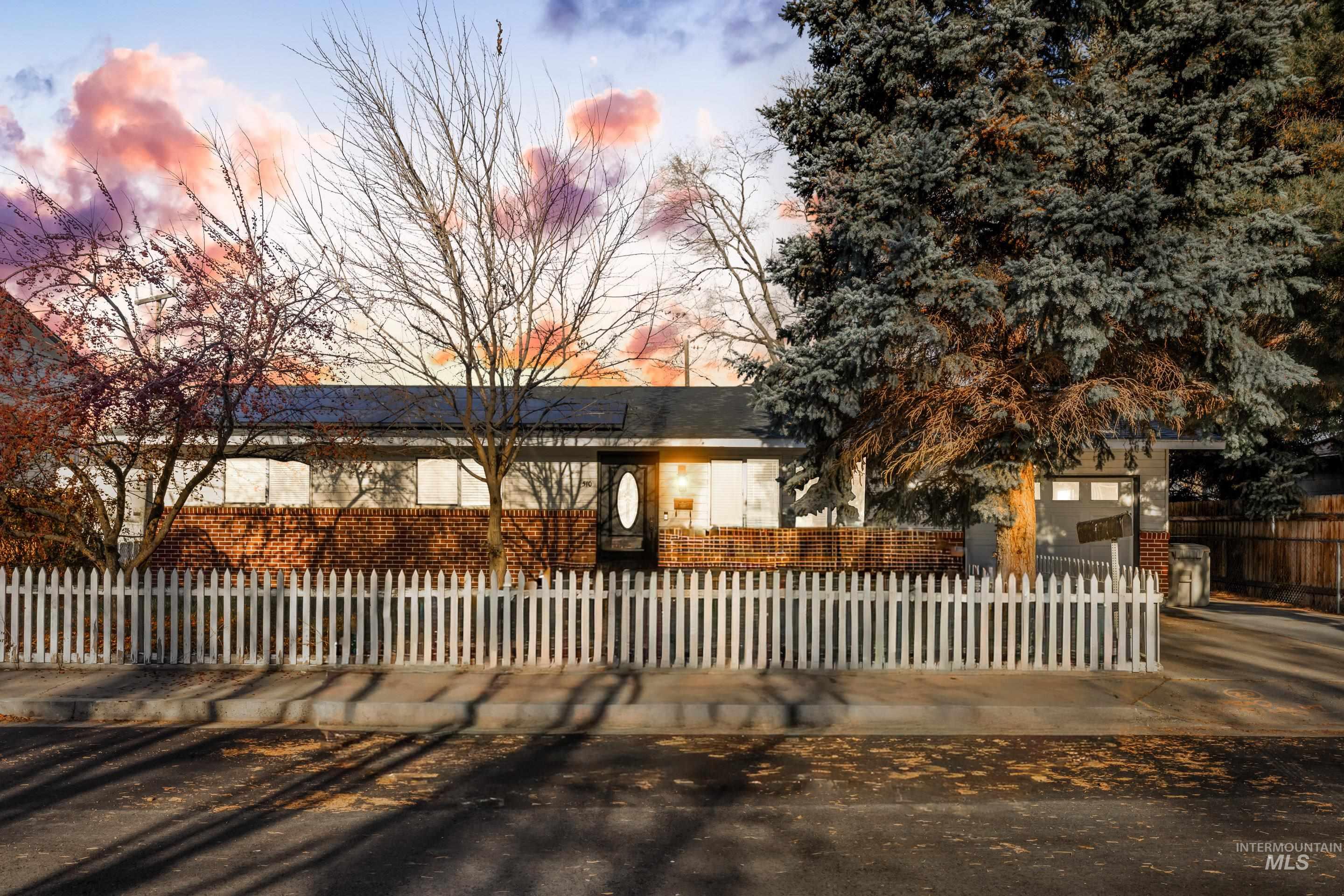 View of front facade featuring a fenced front yard and brick siding