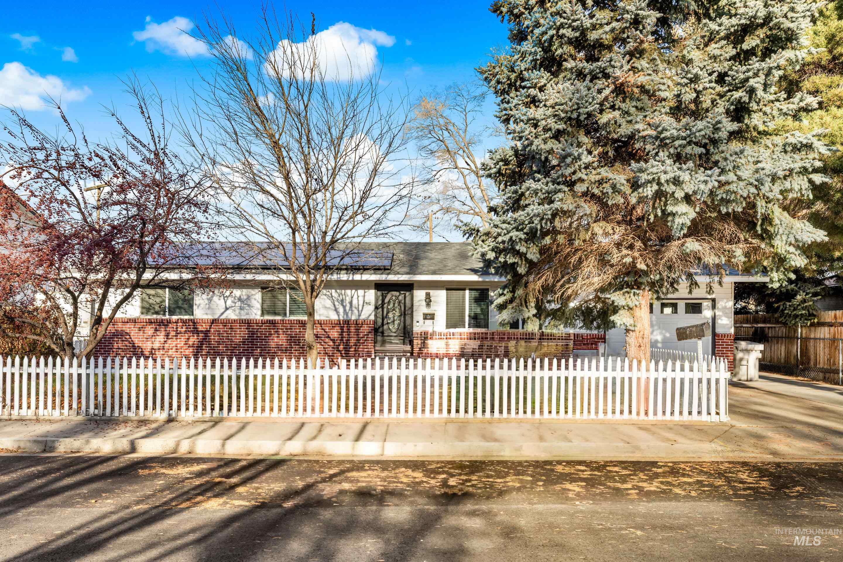 Ranch-style home with brick siding and a fenced front yard