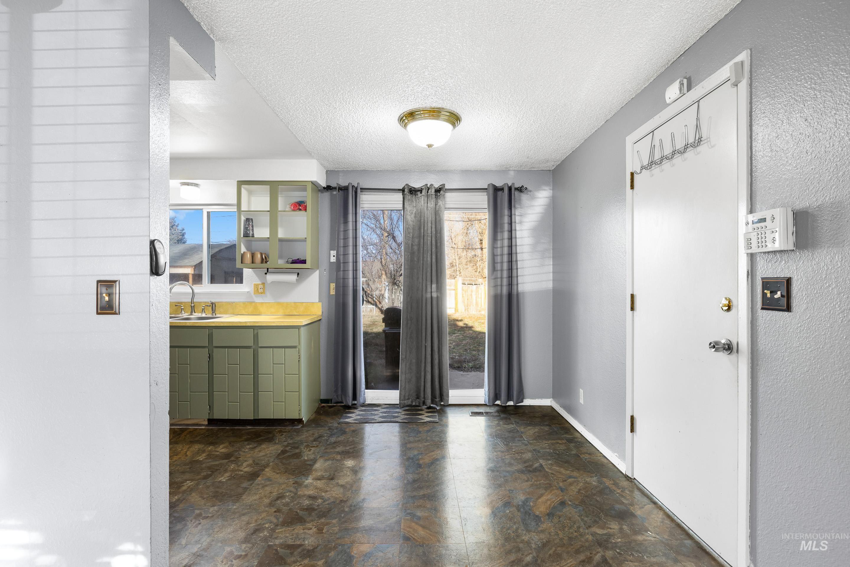Foyer featuring a textured ceiling and stone finish floors