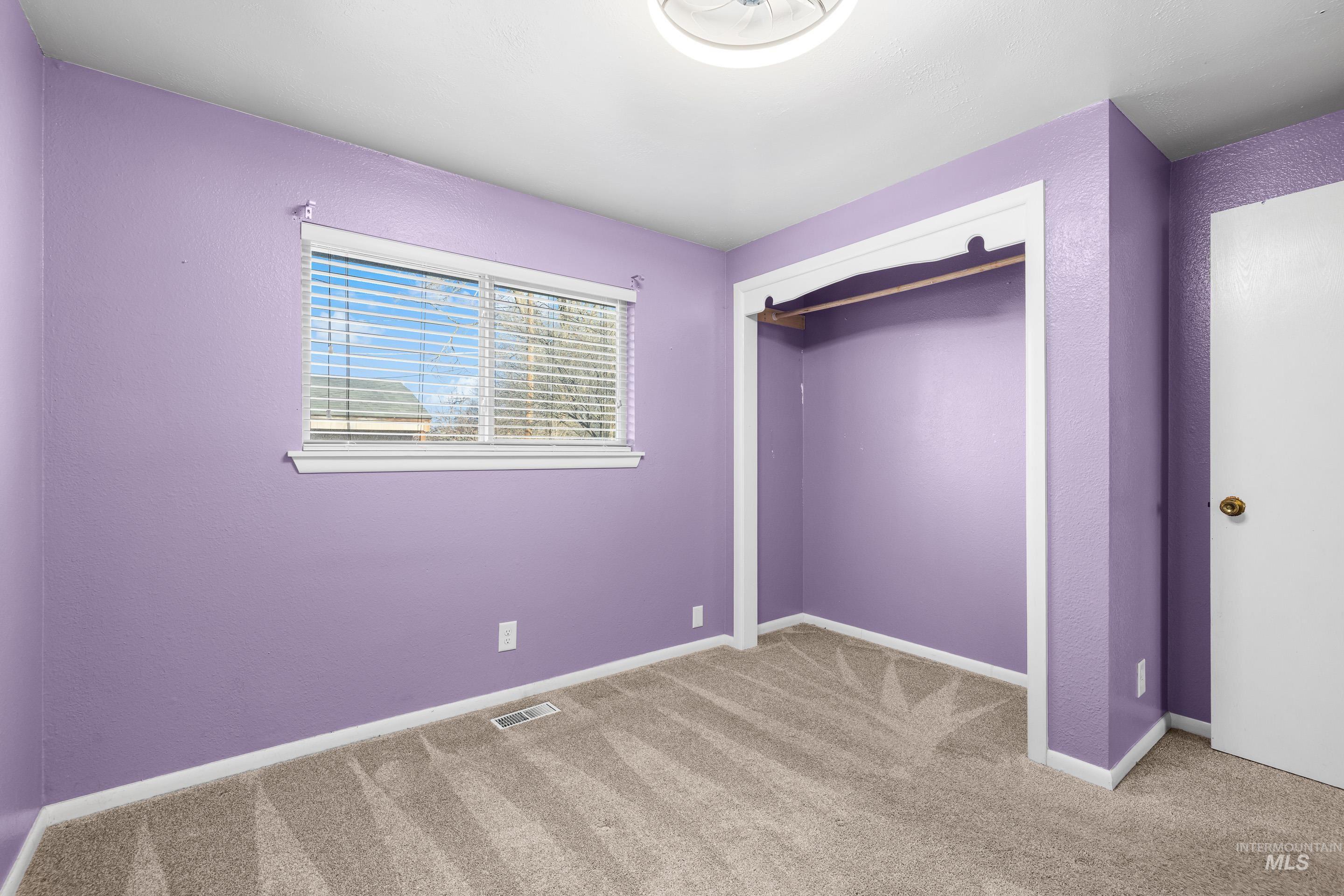 Unfurnished bedroom with carpet, a closet, and a textured wall