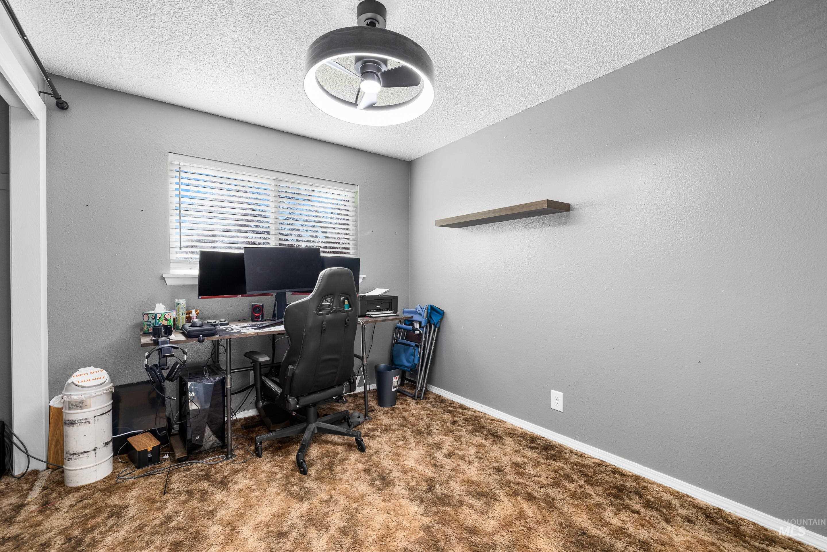 Office featuring a textured wall, a textured ceiling, and carpet