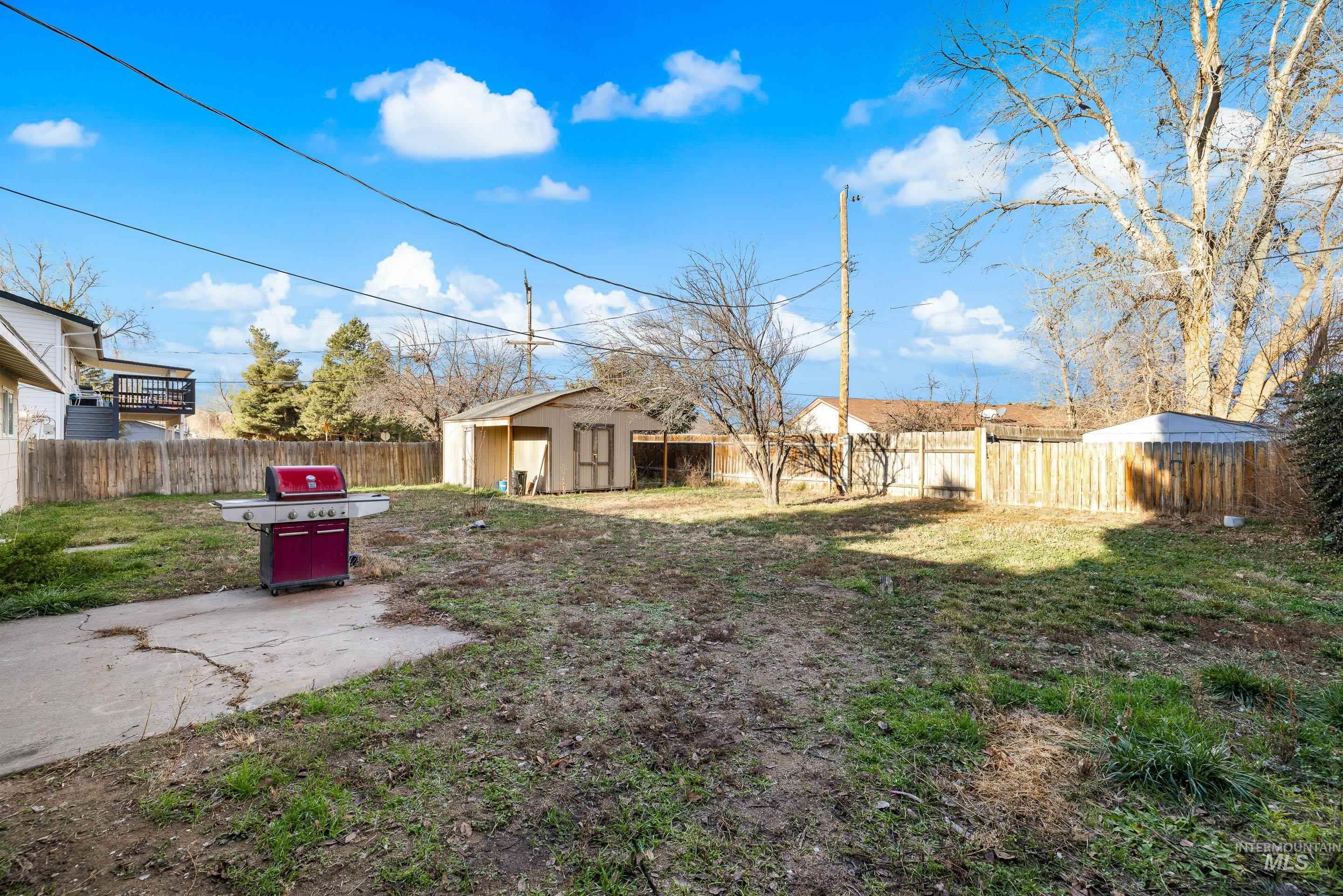 Fenced backyard featuring an outdoor structure