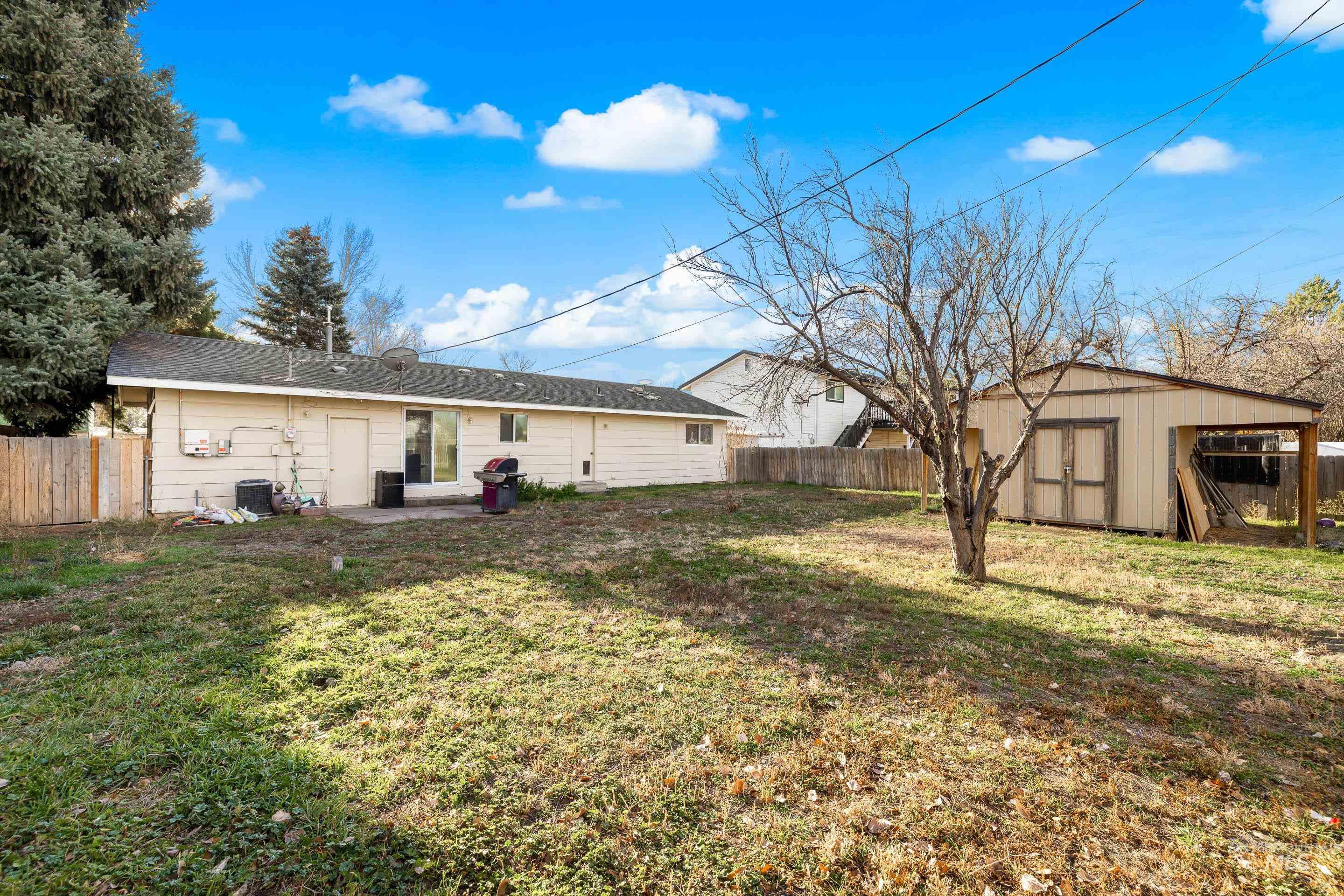 Rear view of house with a fenced backyard, an outdoor structure, and a patio area