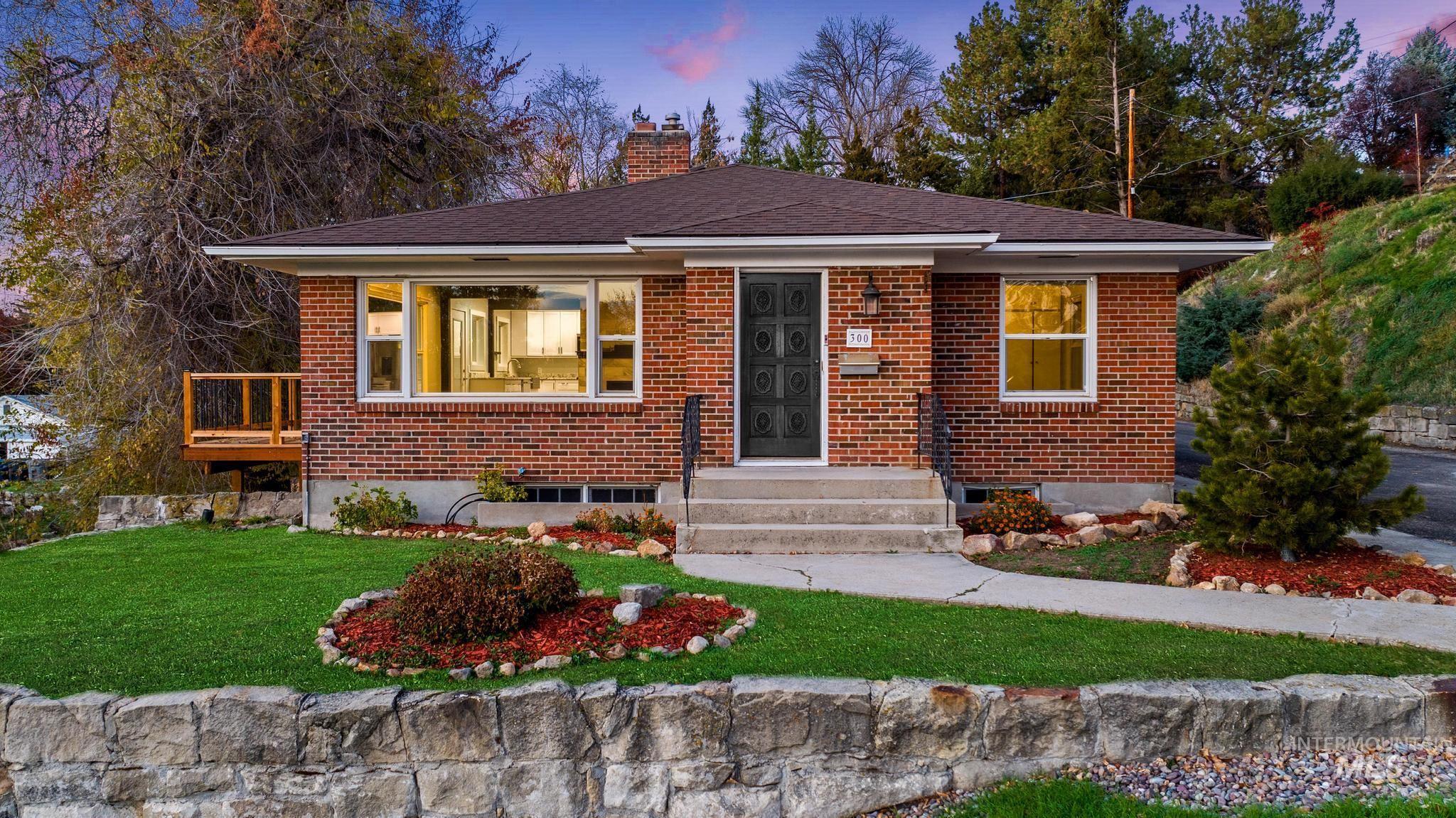 Bungalow with a chimney, brick siding, a lawn, and a shingled roof