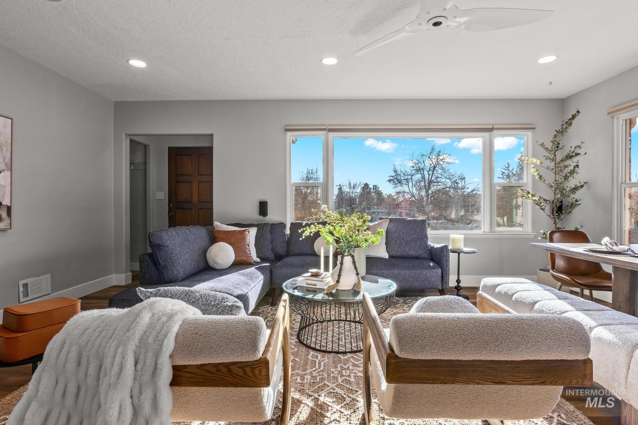 Living area featuring ceiling fan, plenty of natural light, recessed lighting, wood finished floors, and a textured ceiling