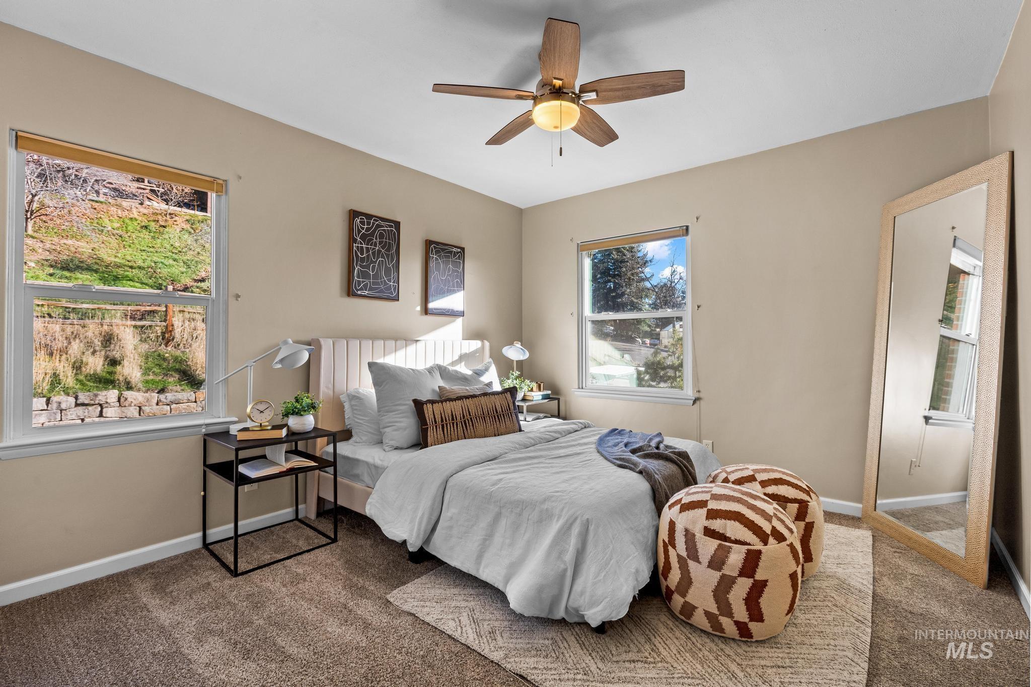 Carpeted bedroom with baseboards and ceiling fan