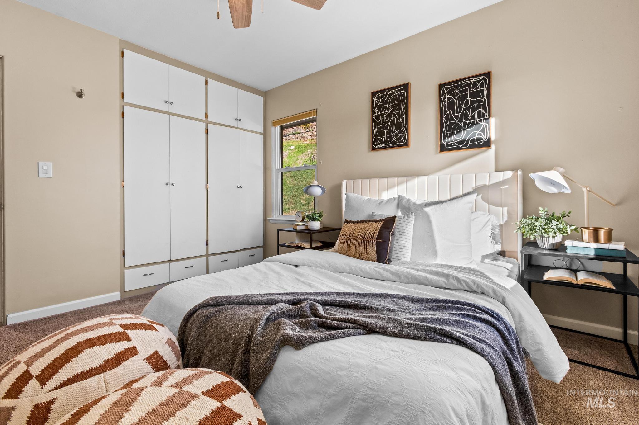 Carpeted bedroom with a closet and a ceiling fan