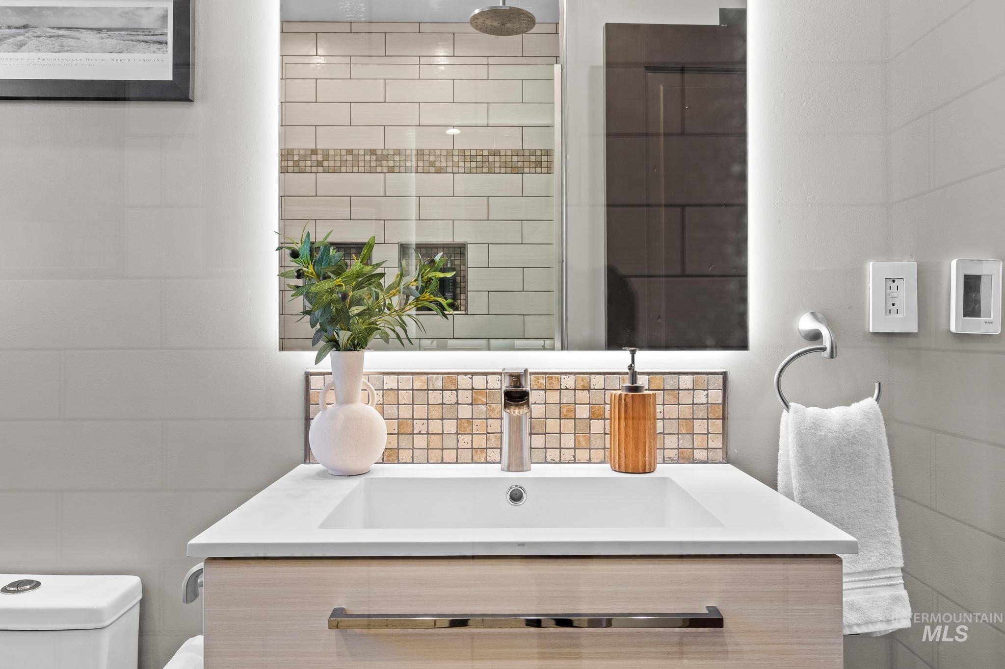 Bathroom with vanity, tile walls, and backsplash