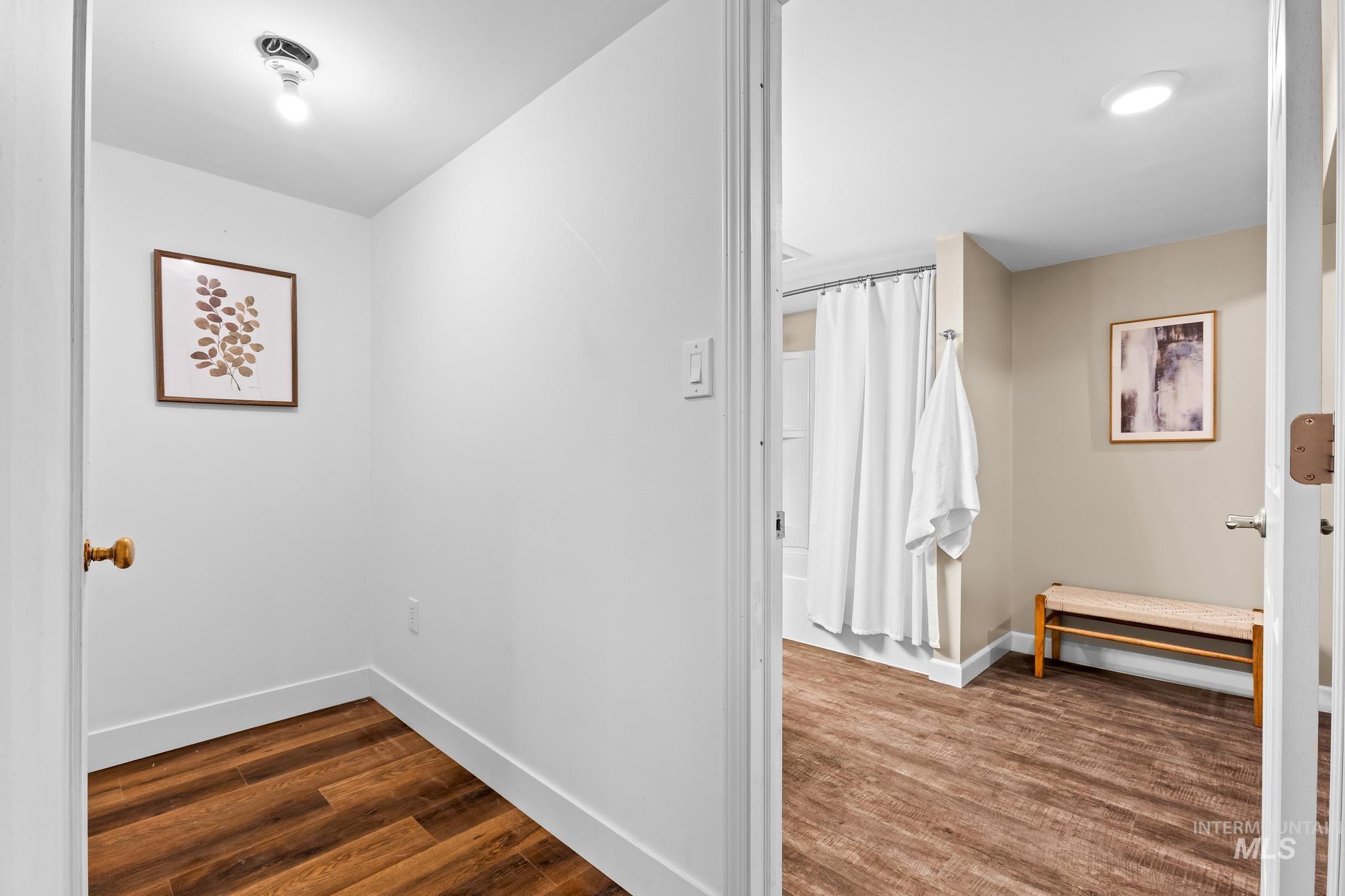 Corridor featuring dark wood-type flooring and baseboards