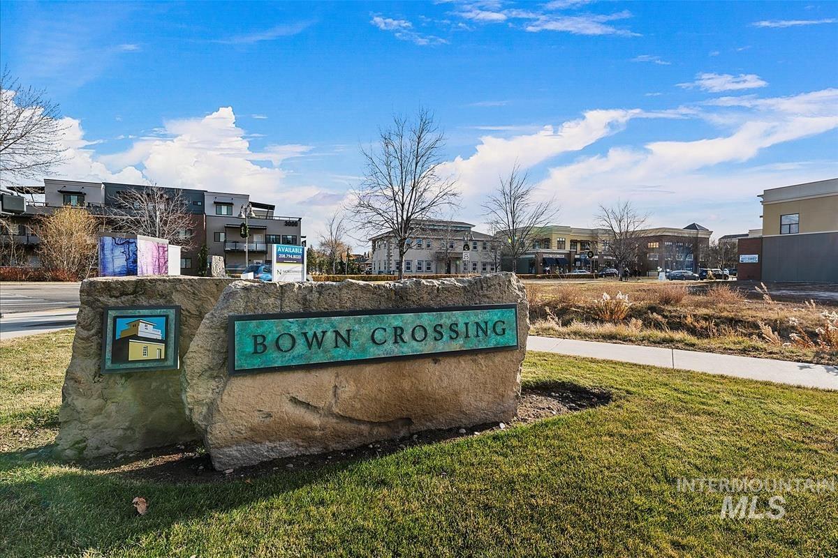 Community sign featuring a lawn and a residential view