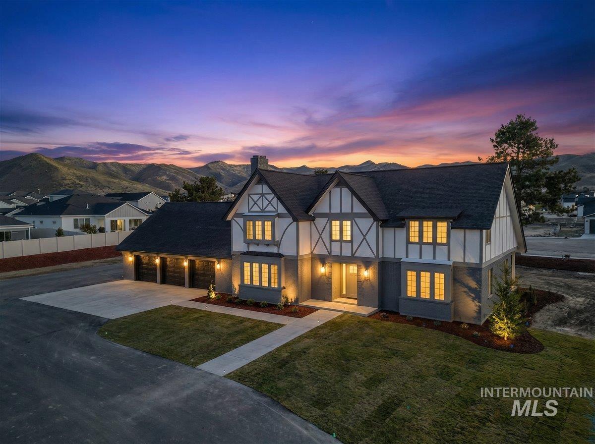English style home with driveway, a chimney, and a mountain view