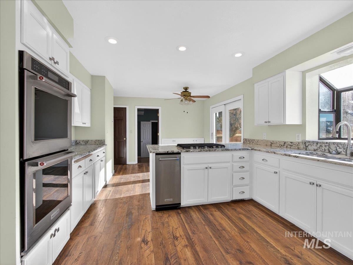 Kitchen featuring stainless steel appliances, white cabinets, a peninsula, and recessed lighting