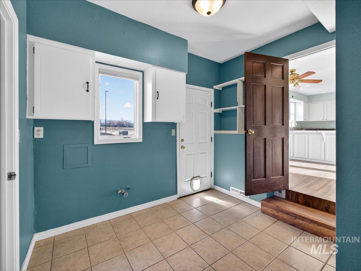 Foyer entrance featuring light tile patterned floors and a ceiling fan