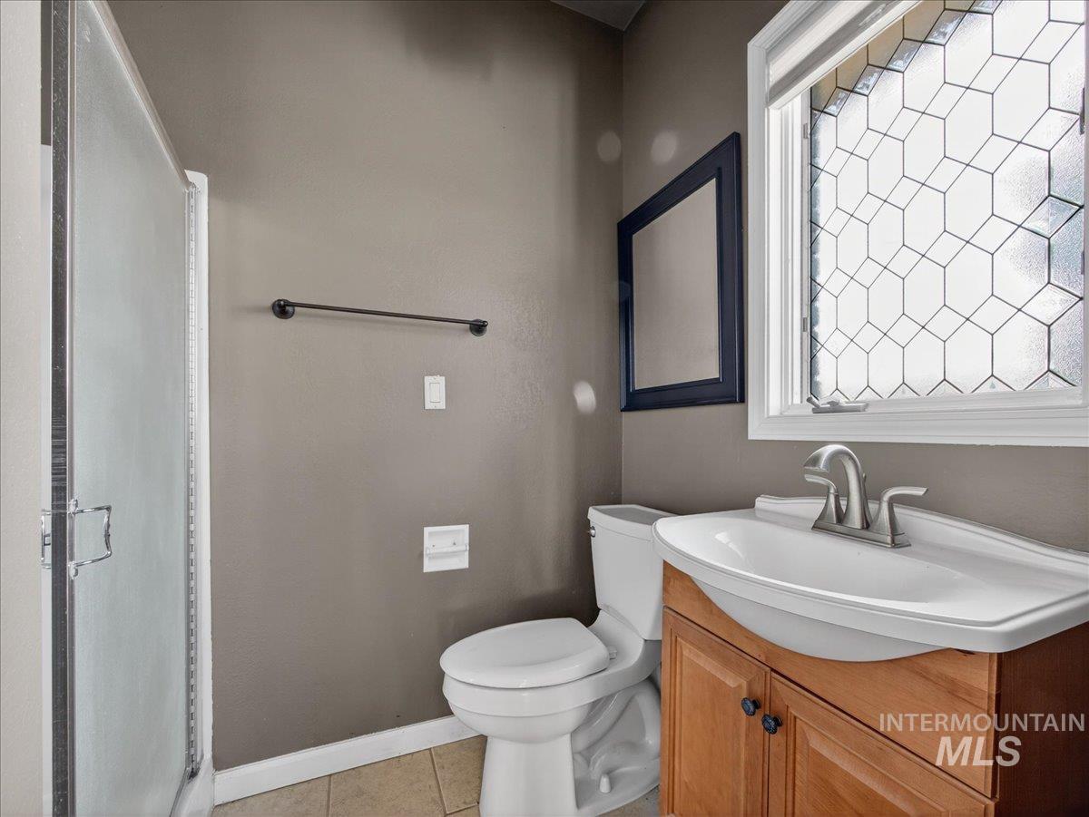 Bathroom featuring vanity, light tile patterned flooring, and a shower stall