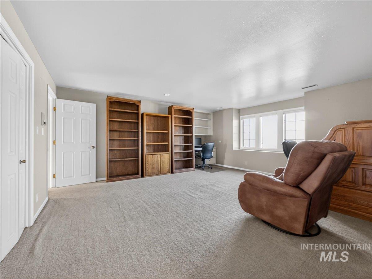 Sitting room with a desk and carpet flooring
