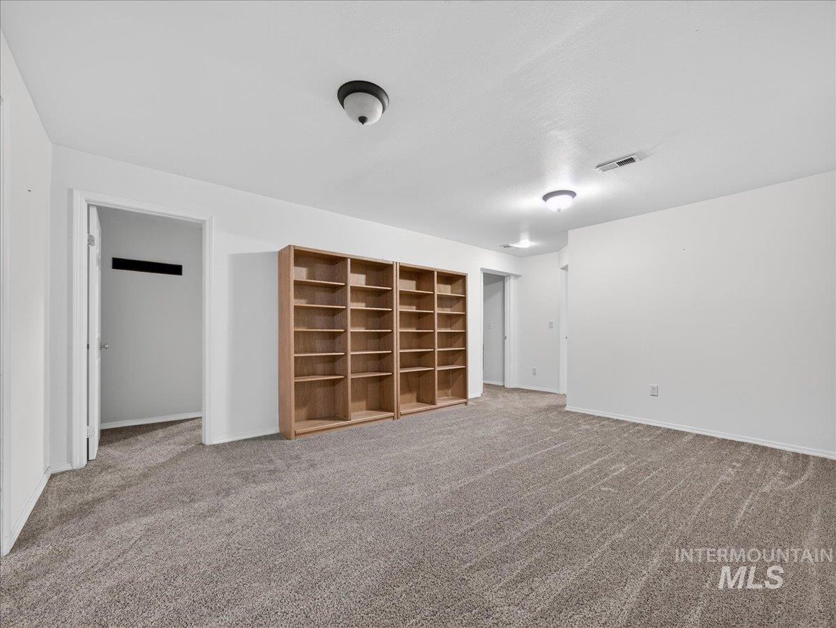 Unfurnished living room featuring carpet flooring and baseboards