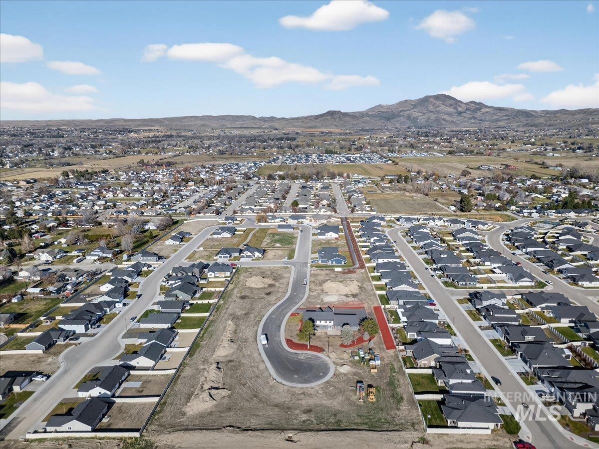 Aerial overview of property's location featuring nearby suburban area and a mountain backdrop