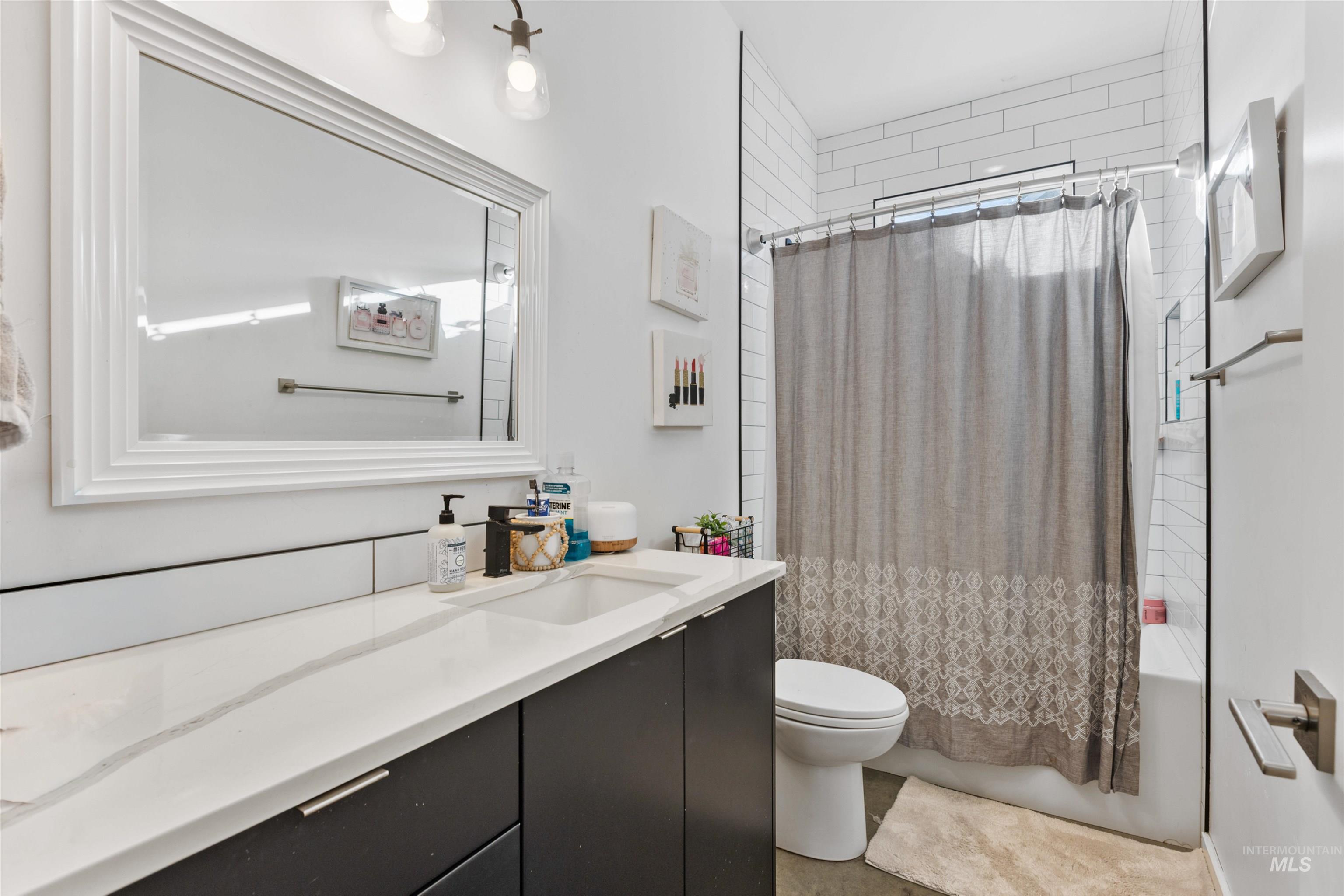 Full bath with shower / bath combination with curtain and vanity