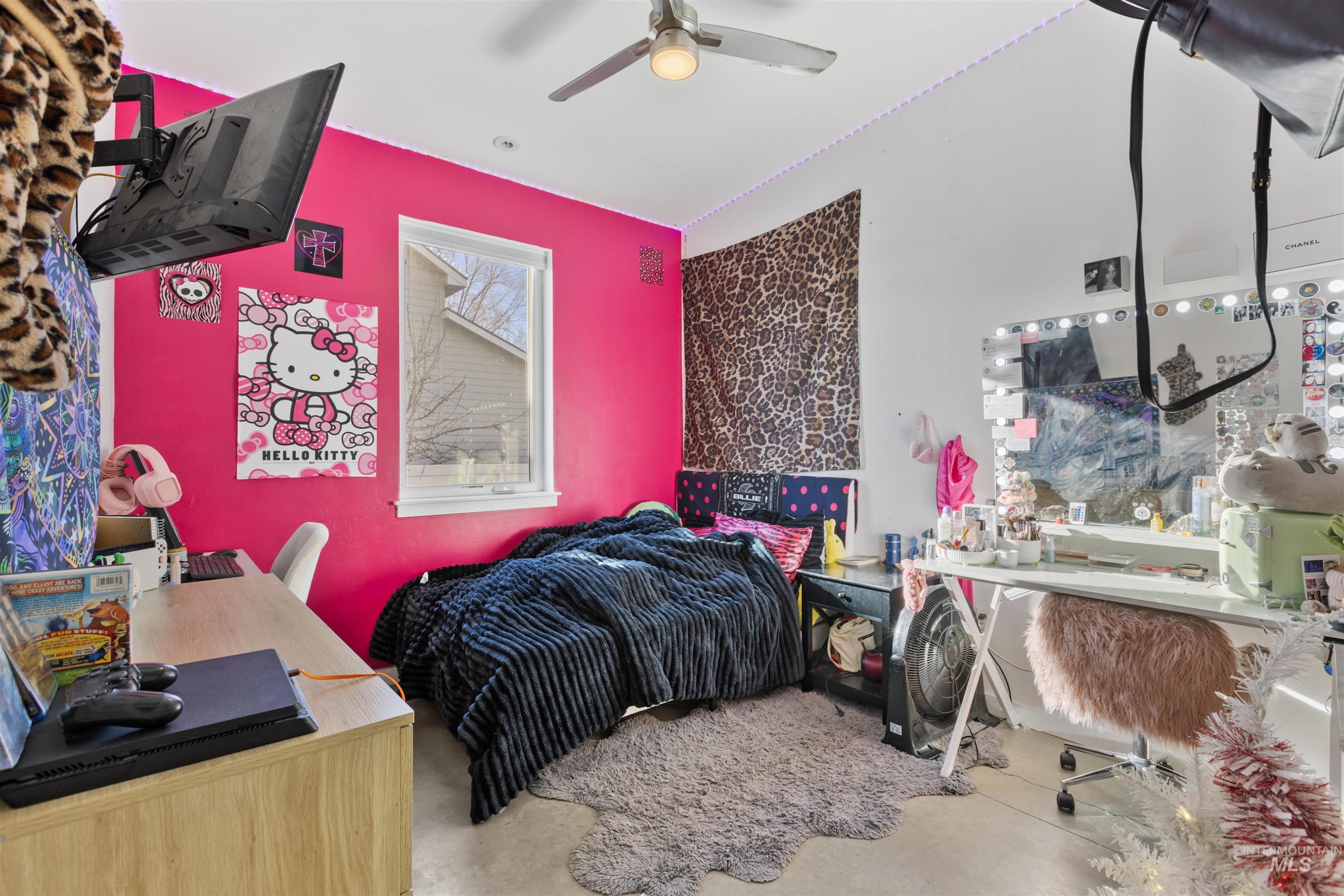 Bedroom with a desk, a ceiling fan, and concrete floors