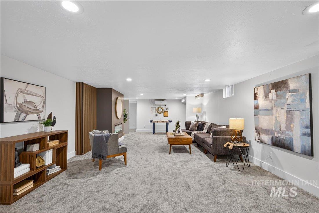 Living area with recessed lighting, light colored carpet, and a textured ceiling