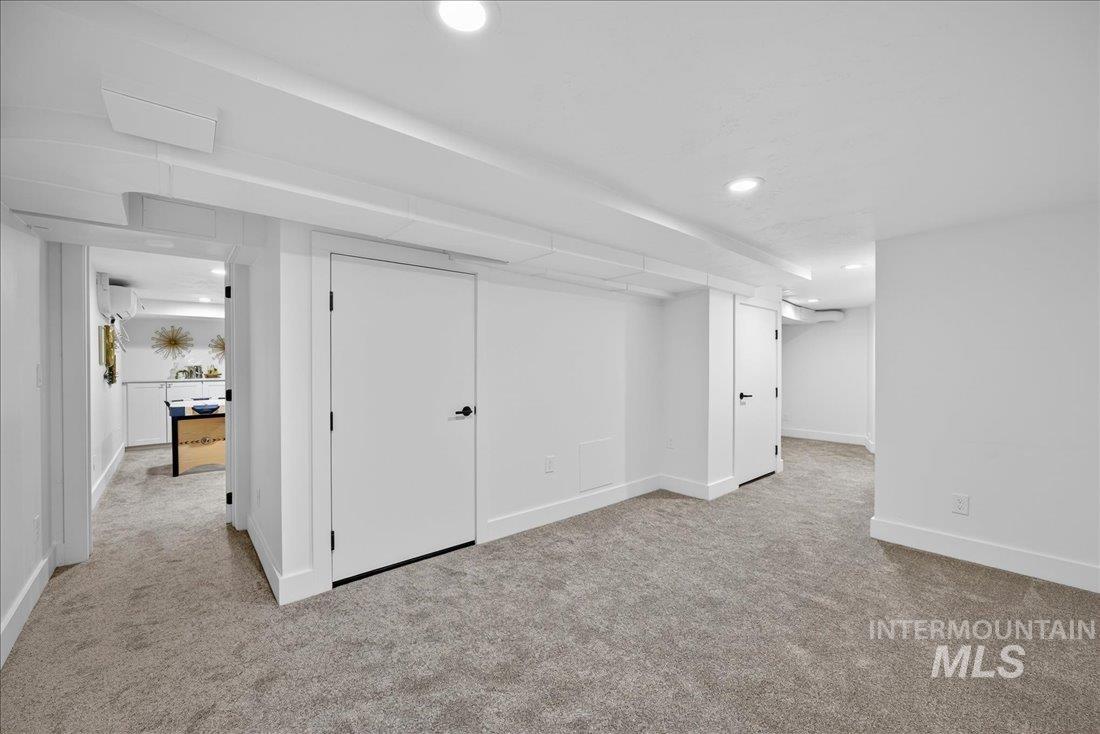 Finished below grade area featuring light carpet and recessed lighting