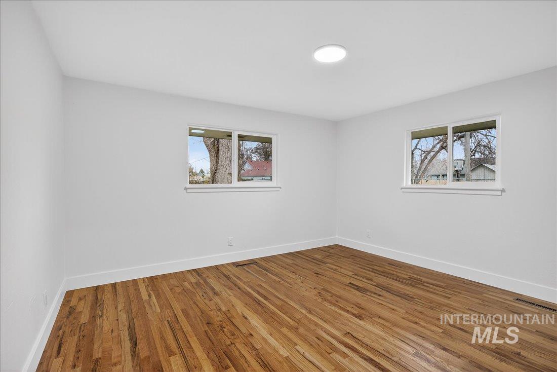 Spare room featuring wood finished floors and plenty of natural light