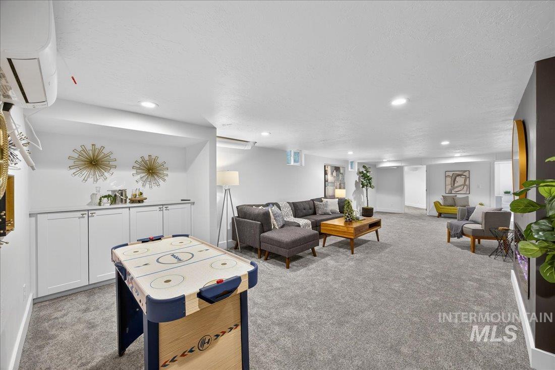 Living room with light colored carpet, a textured ceiling, and recessed lighting