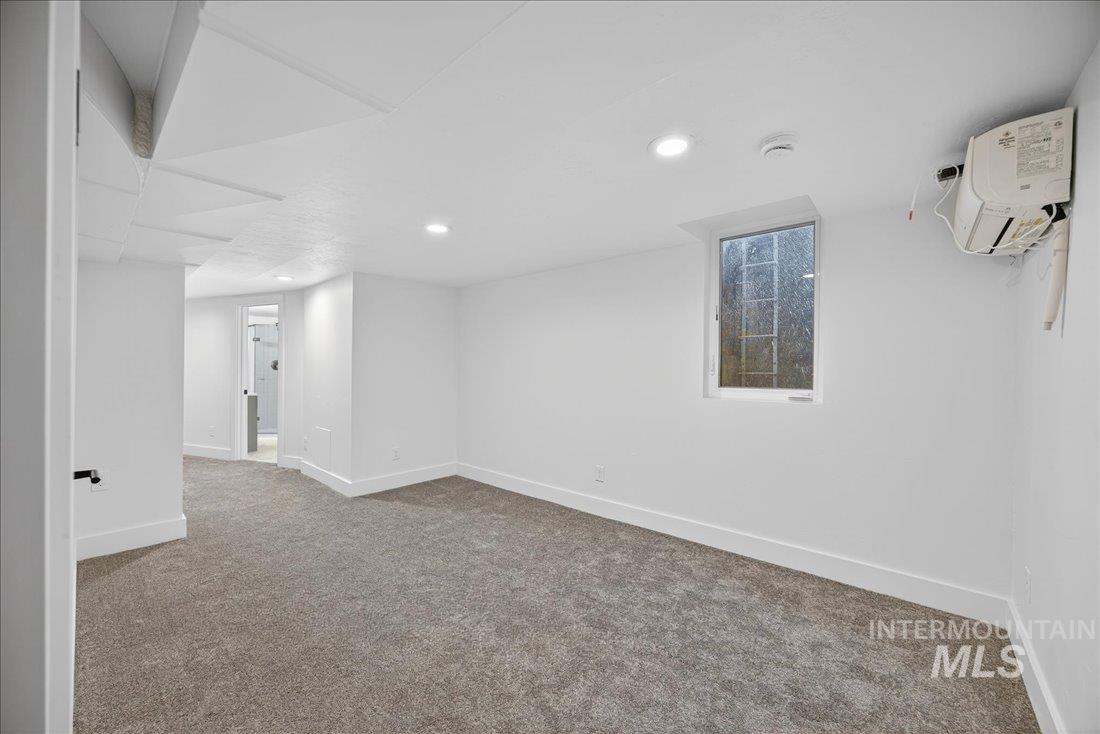 Basement featuring carpet flooring, recessed lighting, and a wall mounted AC