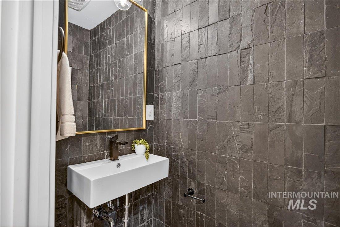 Half bath with a sink and tile walls