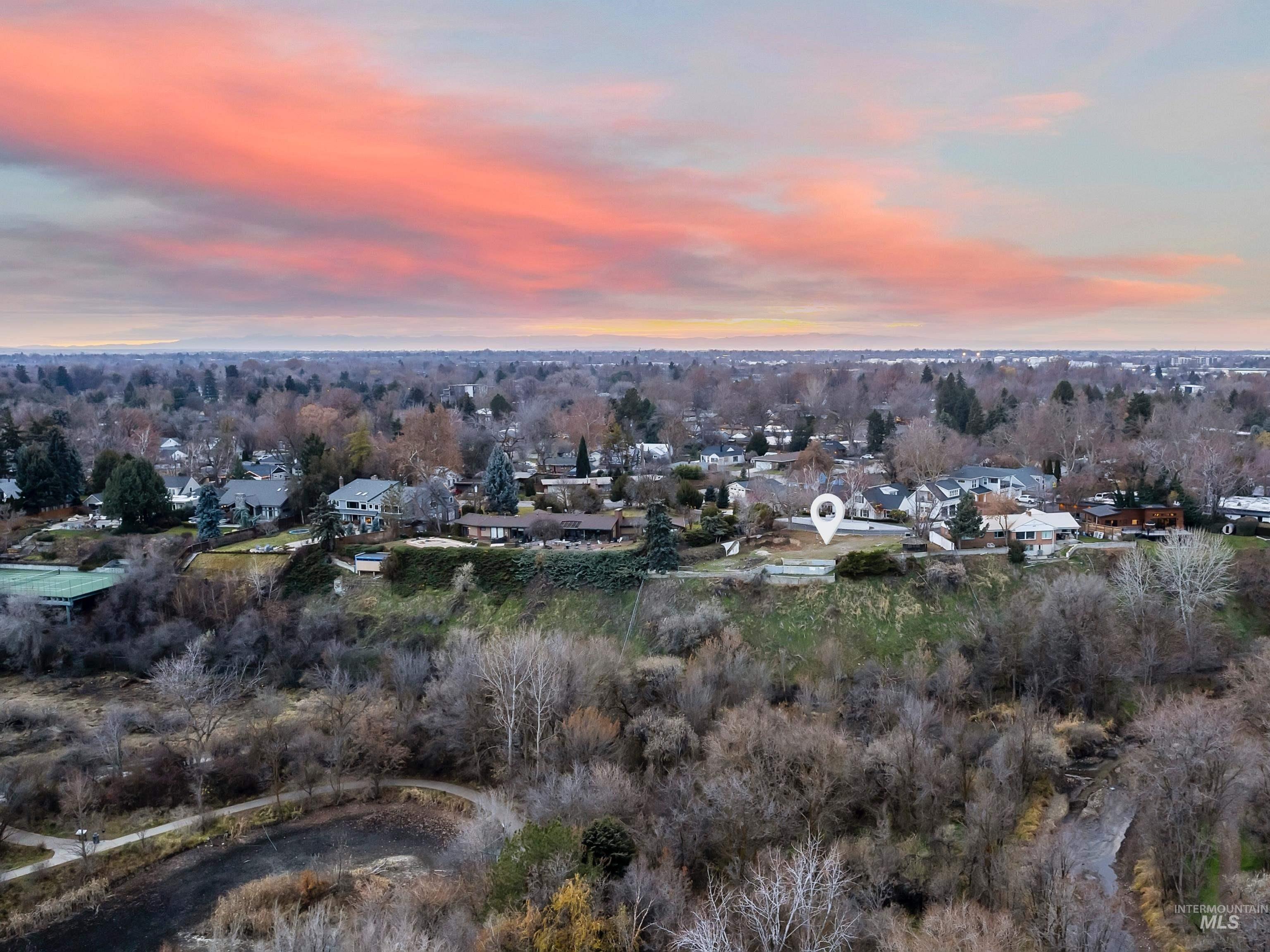 Aerial view at dusk of a residential view and view of wooded area