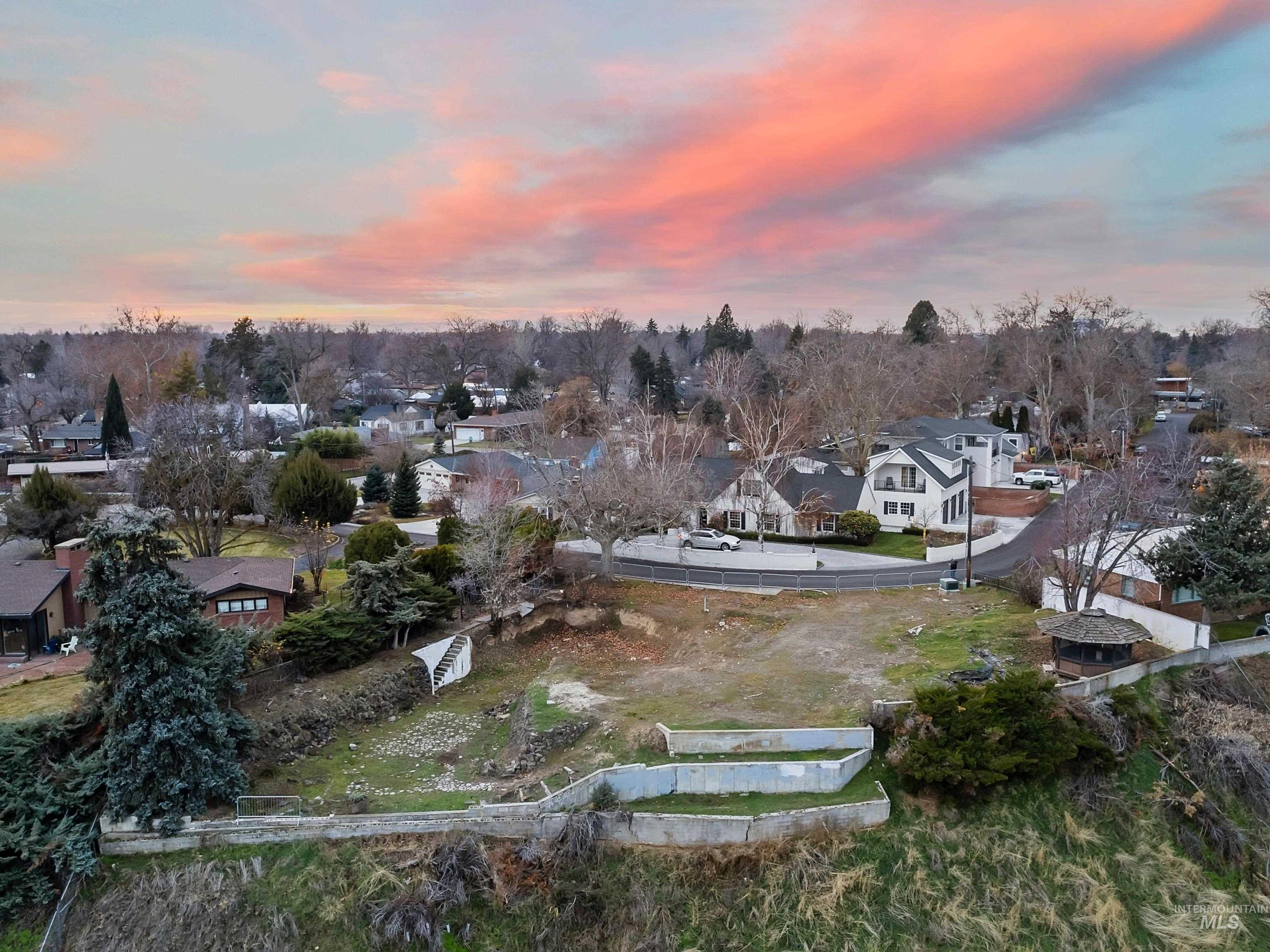 Aerial overview of property's location featuring nearby suburban area and a tree filled landscape