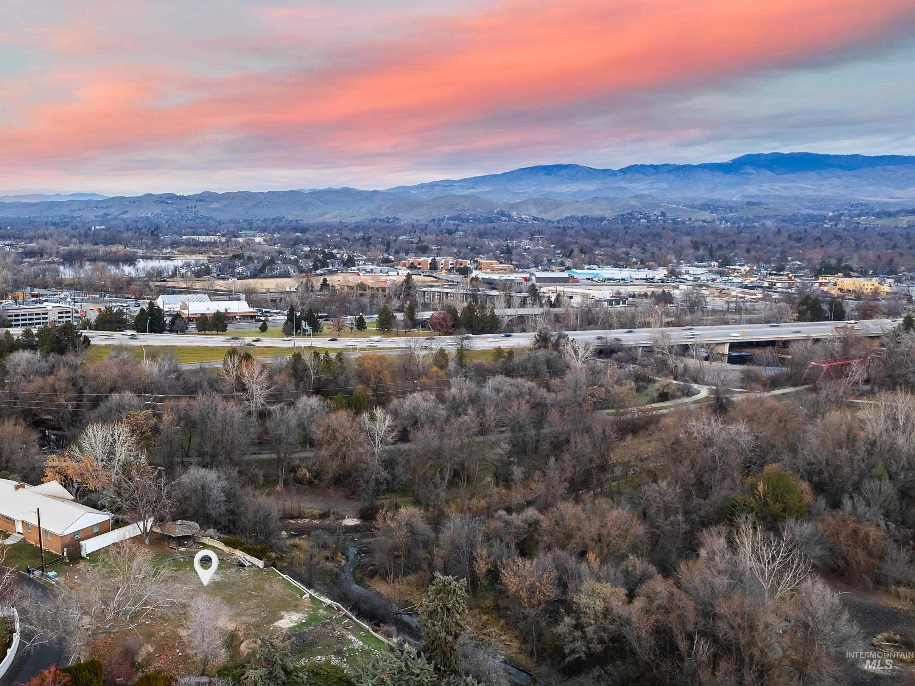 Aerial view of property and surrounding area with a mountainous background