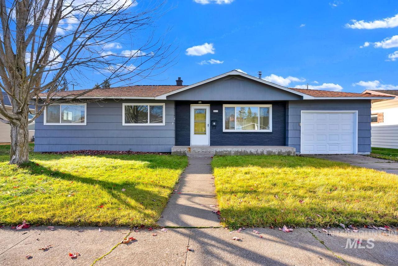 Ranch-style house with a front yard and an attached garage