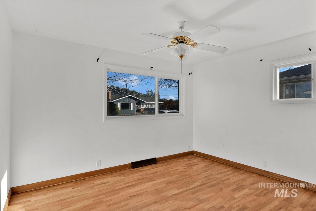 Empty room with light wood-style flooring and ceiling fan